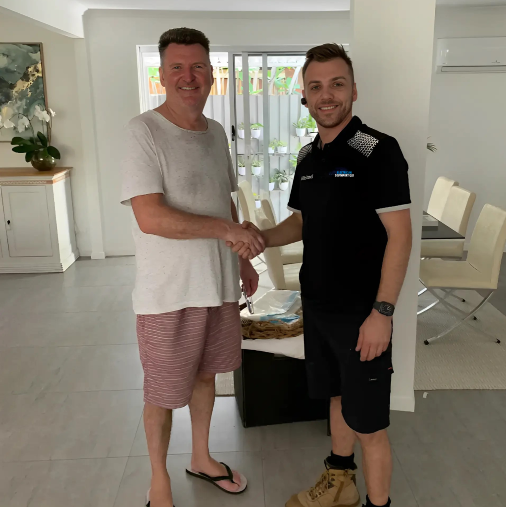 A professional and a customer shaking hands inside a well-lit living room